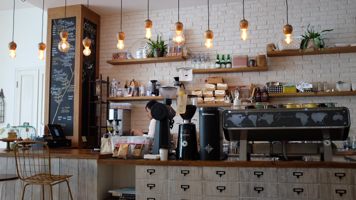 An espresso counter with pendant lights against a white brick wall